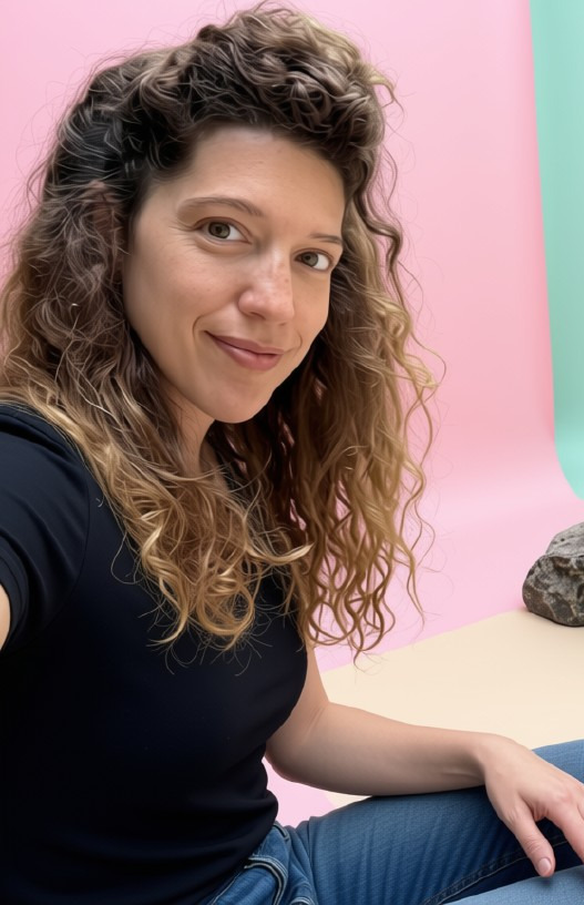 דנה וסרמן מחייכת על רקע ורוד ותכלת